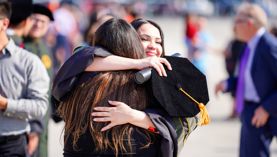 Graduate hugging loved one