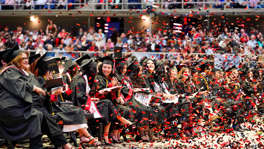 Graduates smiling and celebratory confetti