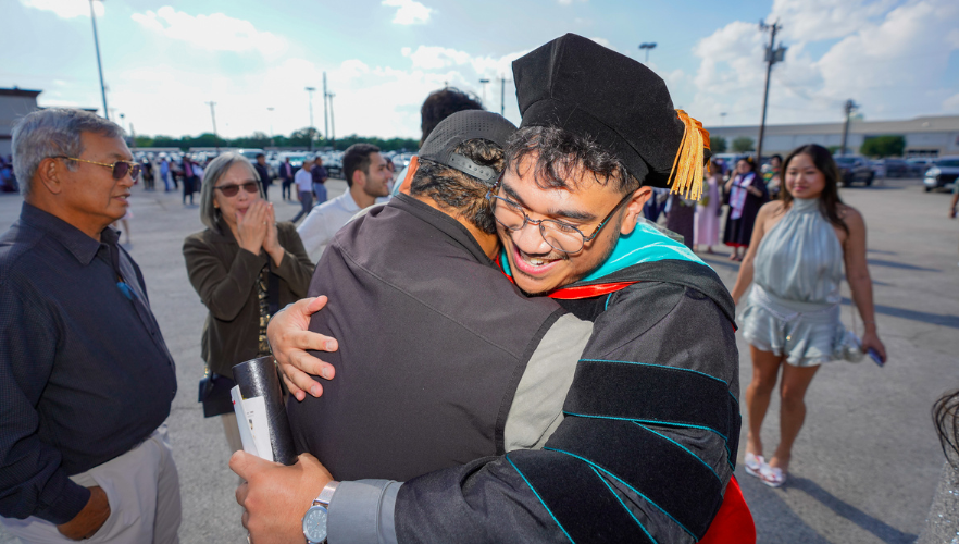 Graduate hugging loved one