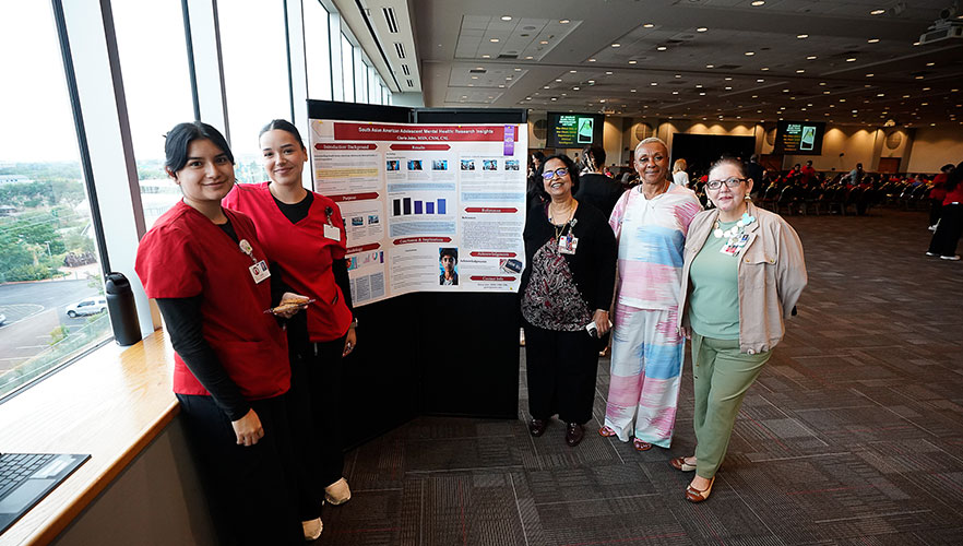 students posing by poster