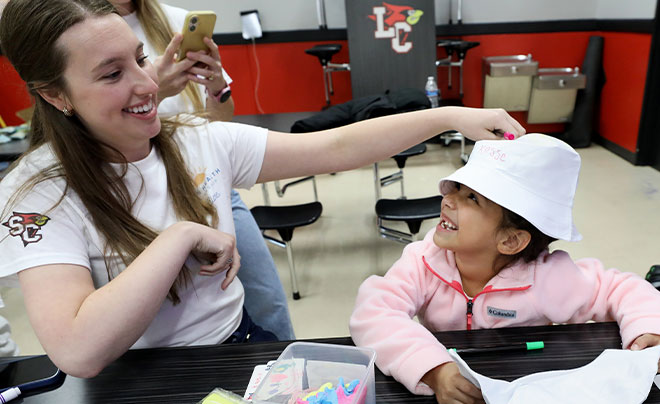 student with kid in hat
